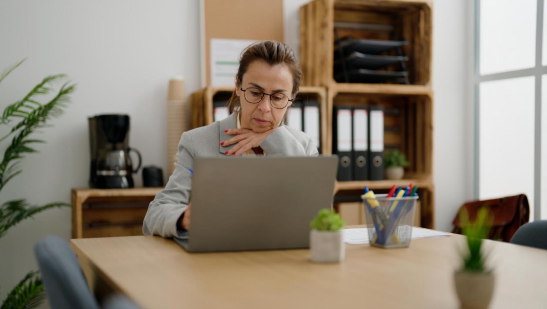 Person reviewing monthly expenses on tablet with coffee cup nearby